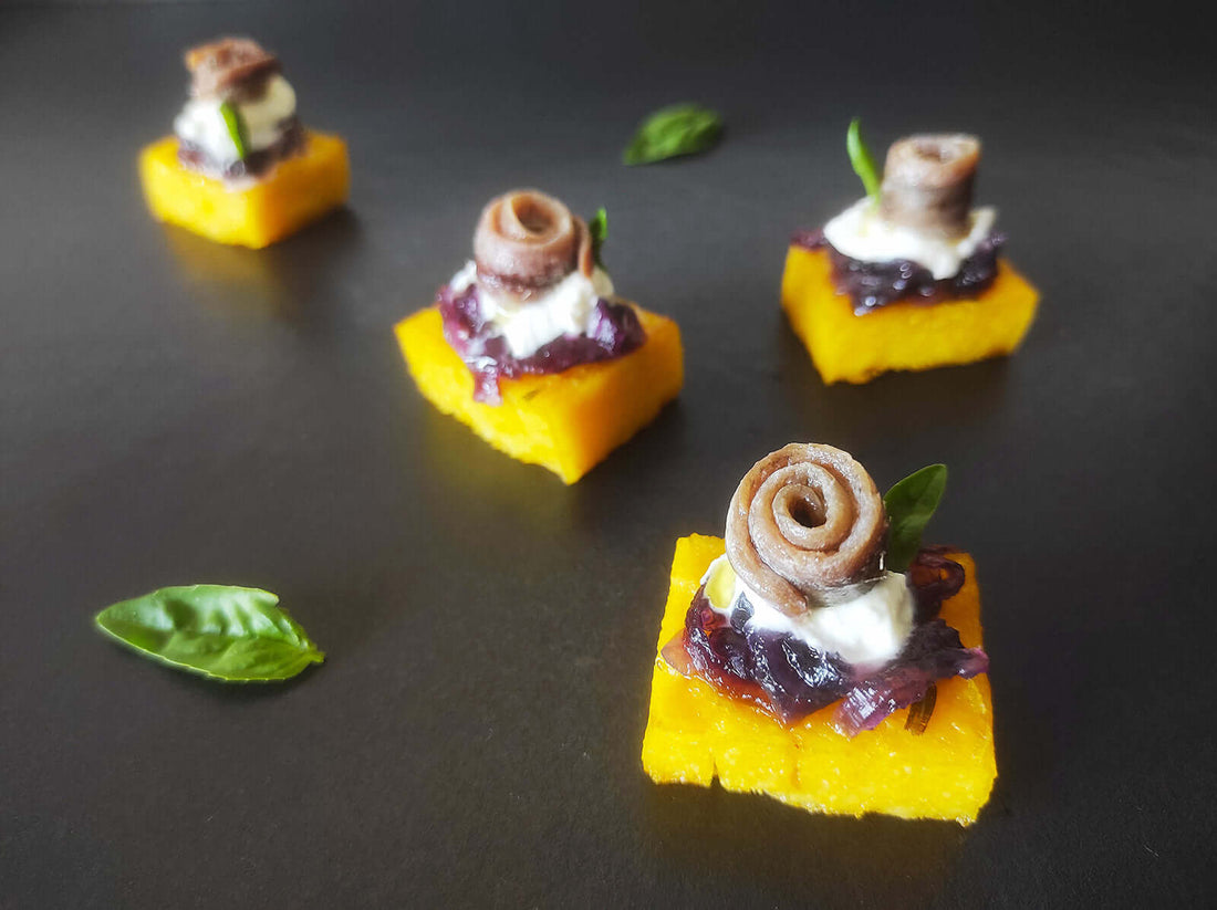 Crostini di polenta con alici cantabriche, stracciatella e cipolle caramellate